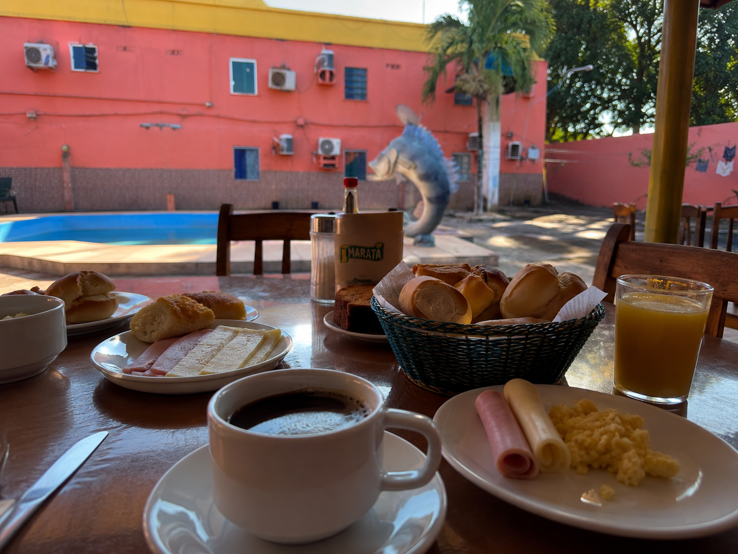 Café da manhã servido na área coberta ao lado da piscina